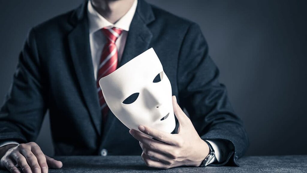 Homem segurando uma mascara indicando tentativa de golpe
